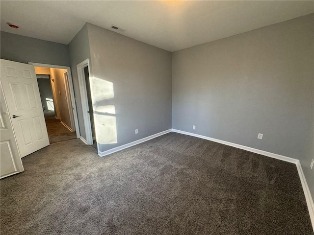unfurnished bedroom featuring dark carpet and baseboards