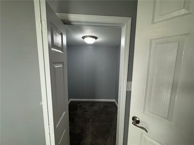 hall with carpet, baseboards, and a textured ceiling