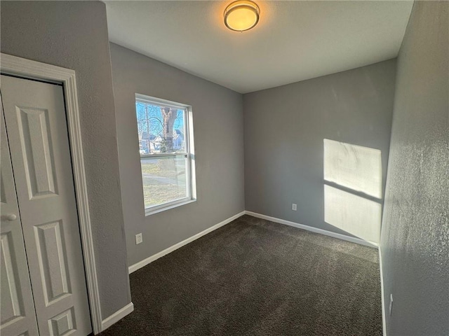 empty room featuring carpet floors and baseboards