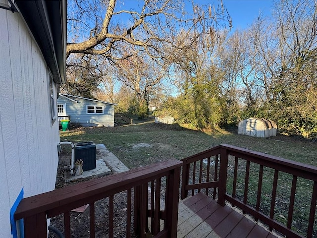 deck with cooling unit, an outbuilding, a yard, and a shed