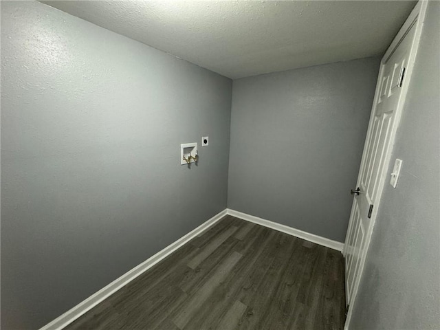 laundry area with hookup for an electric dryer, dark wood-type flooring, washer hookup, baseboards, and a textured ceiling