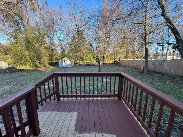 wooden deck featuring a shed and an outdoor structure