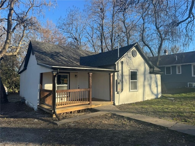 single story home featuring covered porch and roof with shingles