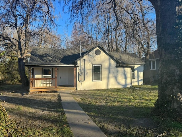 single story home with covered porch, a front lawn, and a shingled roof