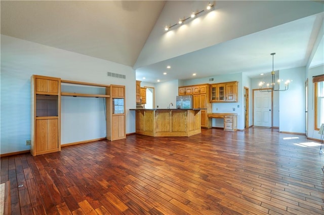 5714 Alden Ct, Shawnee, KS 66216 - unfurnished living room with a chandelier, dark wood-style flooring, baseboards, and high vaulted ceiling