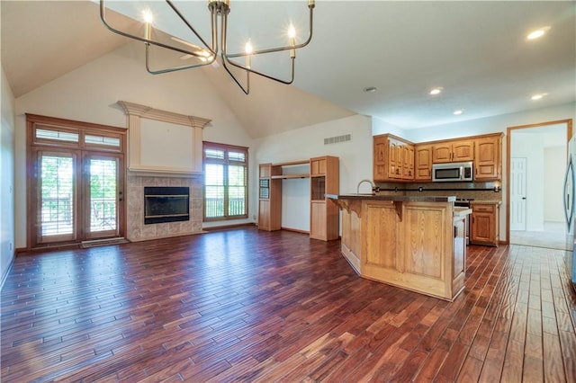 5714 Alden Ct, Shawnee, KS 66216 - kitchen with open floor plan, stainless steel microwave, high vaulted ceiling, dark wood finished floors, and a kitchen breakfast bar