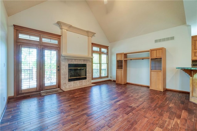 5714 Alden Ct, Shawnee, KS 66216 - unfurnished living room featuring high vaulted ceiling, dark wood-style floors, baseboards, and a tile fireplace