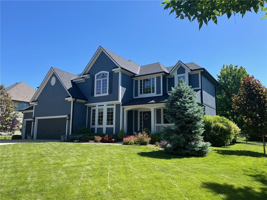 14713 Knox St, Overland Park, KS 66221 - view of front of house with a garage, driveway, and stucco siding