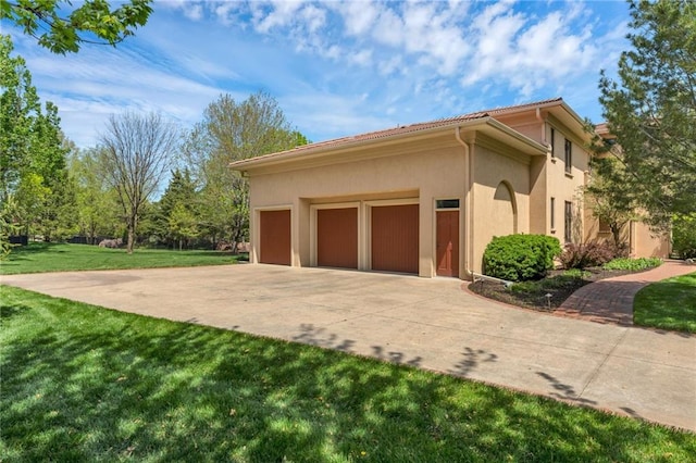 view of property exterior featuring stucco siding, a lawn, concrete driveway, a garage, and a tiled roof