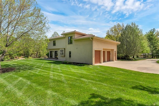 view of property exterior featuring stucco siding, a yard, a garage, and concrete driveway