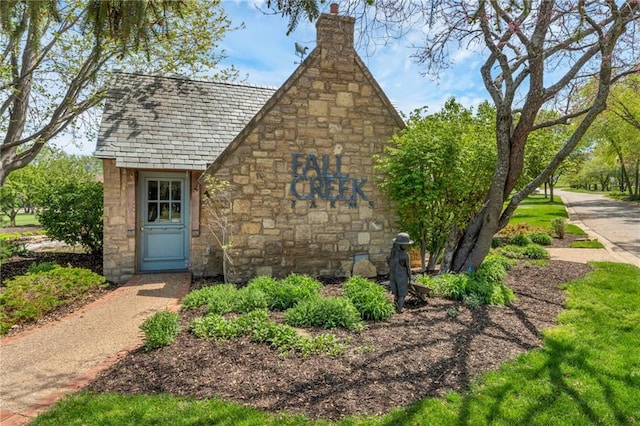 tudor home featuring stone siding and a chimney
