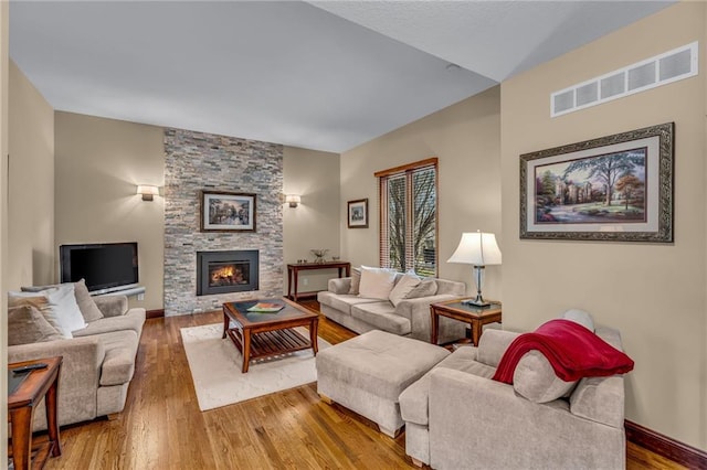 living room featuring wood finished floors, a fireplace, and baseboards