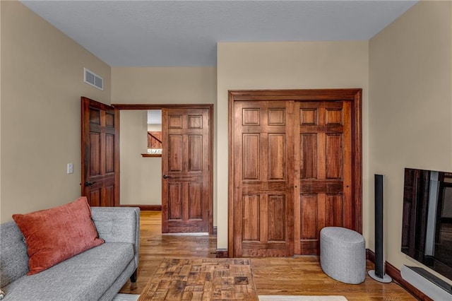 living area with wood finished floors and baseboards