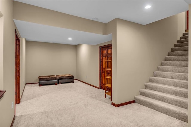 finished below grade area featuring carpet, stairway, baseboards, and recessed lighting
