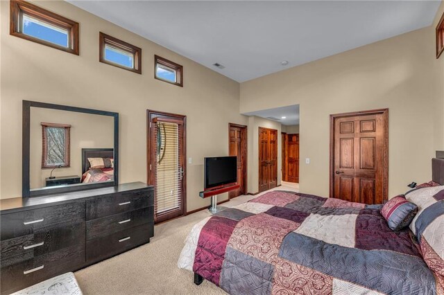 bedroom featuring light carpet and a towering ceiling