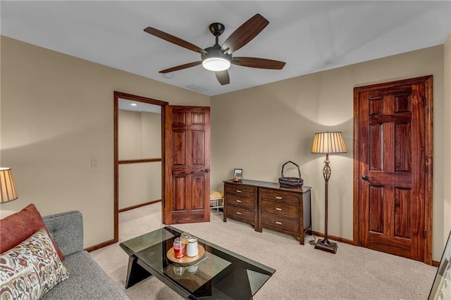 living area featuring a ceiling fan, carpet, and baseboards