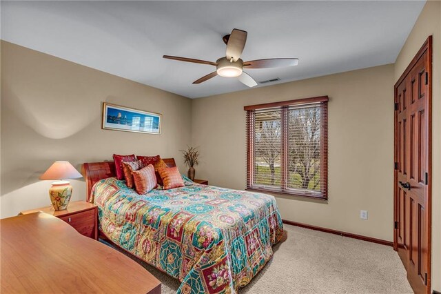 bedroom featuring baseboards, light colored carpet, and a ceiling fan