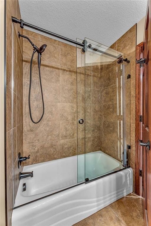 full bathroom with a textured ceiling, shower / bath combination with glass door, and tile patterned floors