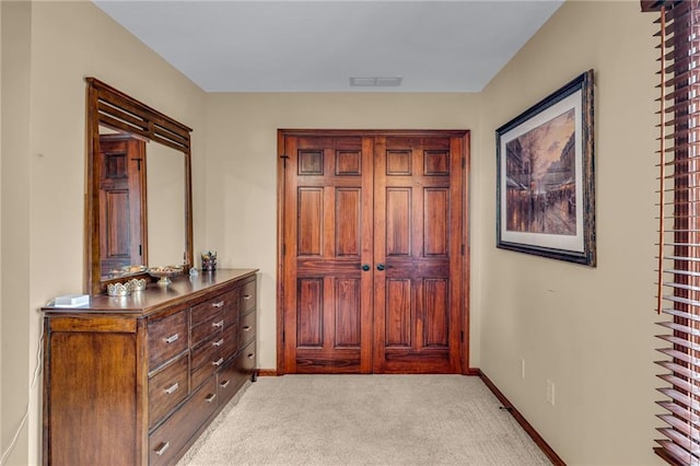 entrance foyer with baseboards and light colored carpet