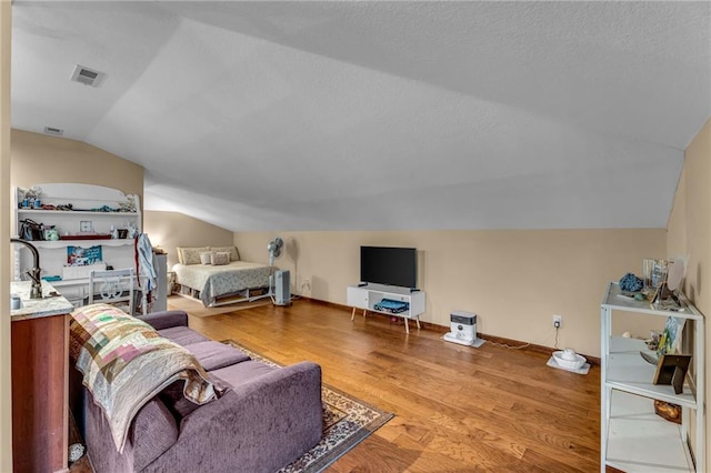 living area with lofted ceiling, wood finished floors, and baseboards