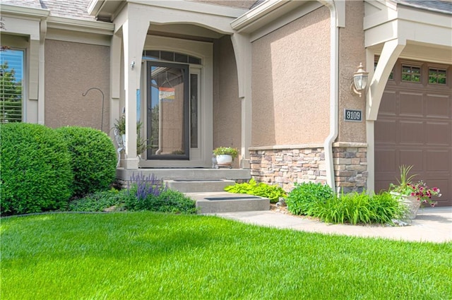 entrance to property with an attached garage, stucco siding, stone siding, and a lawn