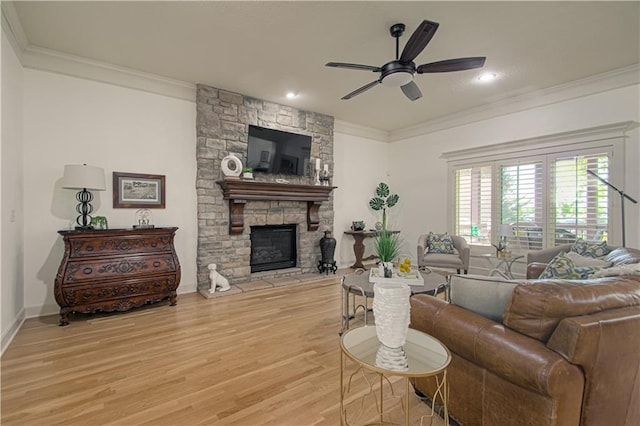 living area featuring wood finished floors, a ceiling fan, crown molding, a fireplace, and baseboards