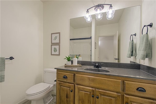 bathroom featuring toilet, vanity, an enclosed shower, and baseboards