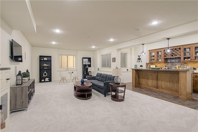 carpeted living area featuring wet bar and recessed lighting