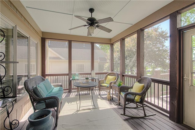 sunroom featuring ceiling fan and an outdoor living space