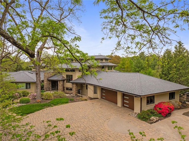 8700 Lee Blvd, Leawood, KS 66206 - view of front of house featuring decorative driveway, an attached garage, and stucco siding