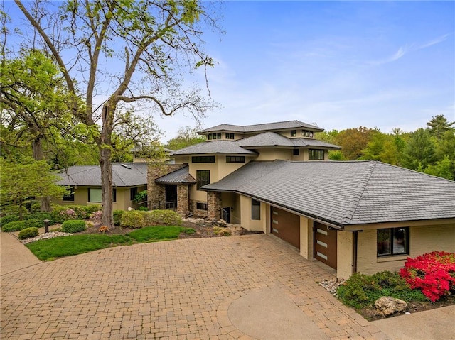 8700 Lee Blvd, Leawood, KS 66206 - prairie-style house featuring curved driveway, a garage, stucco siding, and stone siding