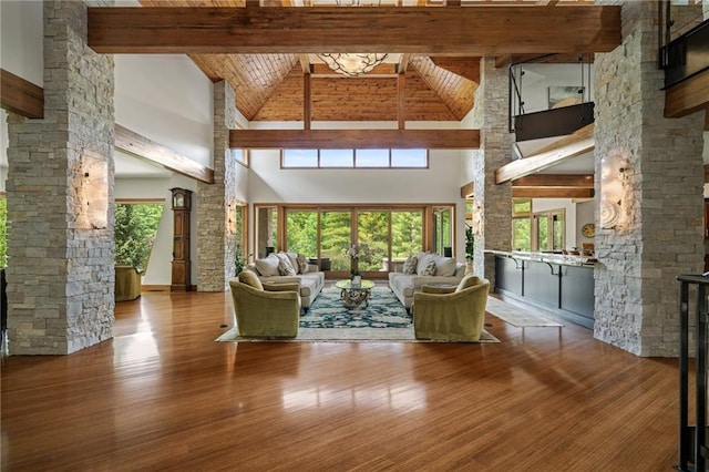 8700 Lee Blvd, Leawood, KS 66206 - living room featuring high vaulted ceiling, beamed ceiling, wood finished floors, and decorative columns