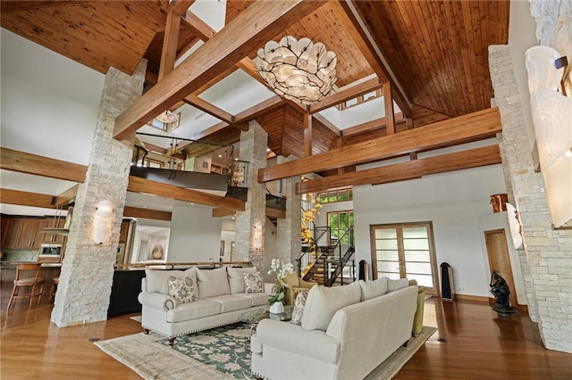 8700 Lee Blvd, Leawood, KS 66206 - living area featuring decorative columns, stairs, a towering ceiling, wood ceiling with exposed beams, and wood finished floors