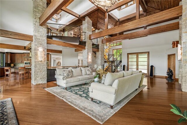 8700 Lee Blvd, Leawood, KS 66206 - living room with ornate columns, a towering ceiling, stairs, wood finished floors, and beam ceiling