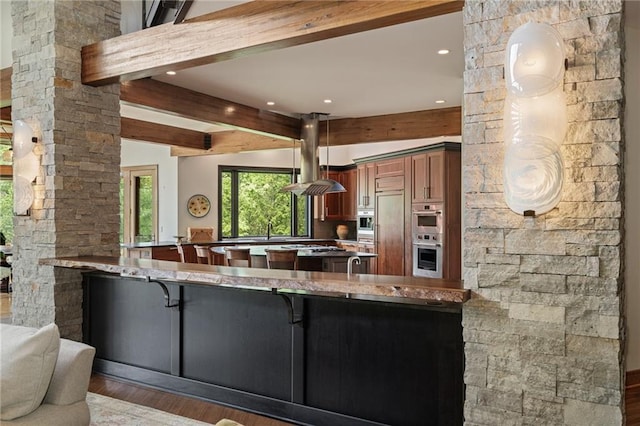 8700 Lee Blvd, Leawood, KS 66206 - kitchen featuring island exhaust hood, beam ceiling, wood finished floors, a peninsula, and recessed lighting
