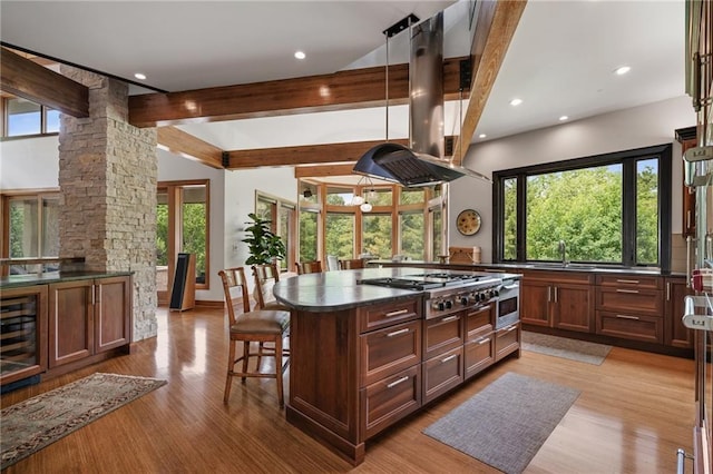 8700 Lee Blvd, Leawood, KS 66206 - kitchen with stainless steel gas cooktop, beamed ceiling, recessed lighting, a breakfast bar area, and light wood-style flooring