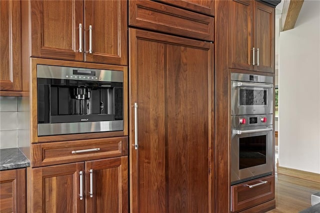 8700 Lee Blvd, Leawood, KS 66206 - kitchen with brown cabinetry, double oven, and wood finished floors