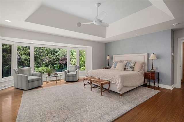 8700 Lee Blvd, Leawood, KS 66206 - bedroom featuring a raised ceiling, wood finished floors, baseboards, ceiling fan, and recessed lighting