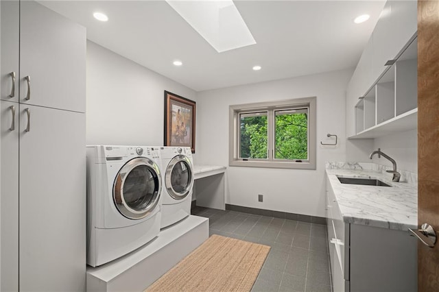 8700 Lee Blvd, Leawood, KS 66206 - washroom featuring cabinet space, washing machine and dryer, a skylight, dark tile patterned floors, and baseboards