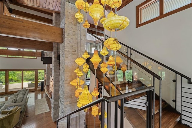 8700 Lee Blvd, Leawood, KS 66206 - staircase featuring a chandelier, wood finished floors, a high ceiling, and wooden ceiling with exposed beams