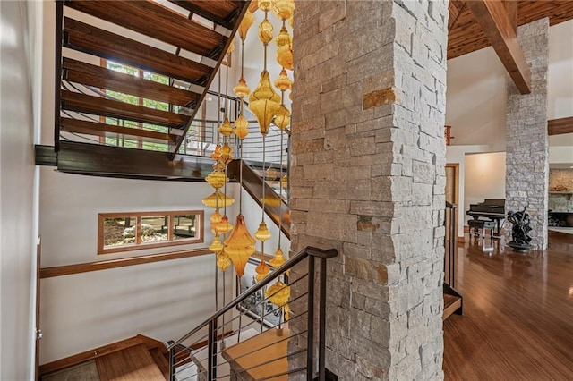 8700 Lee Blvd, Leawood, KS 66206 - stairs with wood finished floors, beamed ceiling, a high ceiling, decorative columns, and a chandelier