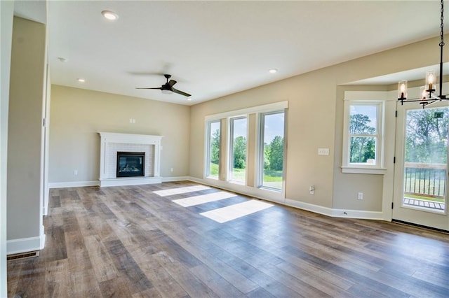 7812 N Spruce Ave, Kansas City, MO 64119 - unfurnished living room featuring wood finished floors, ceiling fan, baseboards, a chandelier, and recessed lighting