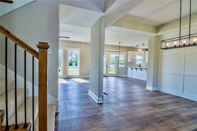 7812 N Spruce Ave, Kansas City, MO 64119 - foyer entrance with a chandelier, dark wood-type flooring, stairway, and baseboards