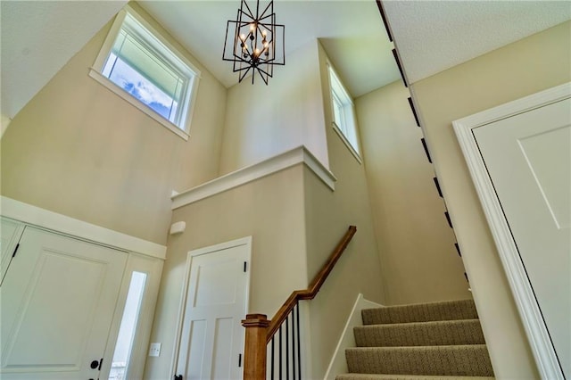 7812 N Spruce Ave, Kansas City, MO 64119 - entrance foyer with stairway, a chandelier, and a high ceiling