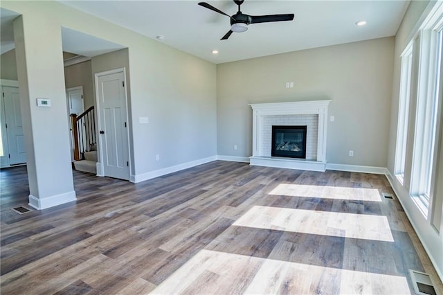 7812 N Spruce Ave, Kansas City, MO 64119 - unfurnished living room featuring a ceiling fan, healthy amount of natural light, stairs, wood finished floors, and recessed lighting