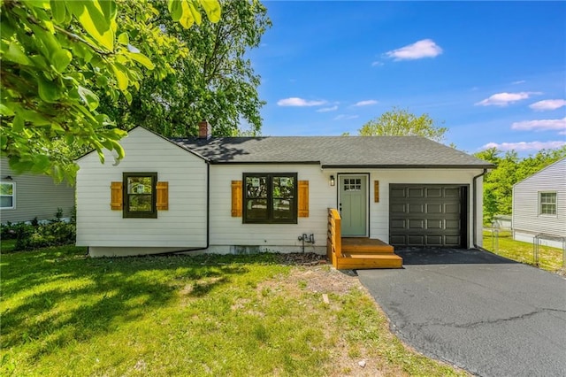 3113 55th St, Kansas City, MO 64119 - ranch-style house featuring a garage, asphalt driveway, a chimney, and a front yard