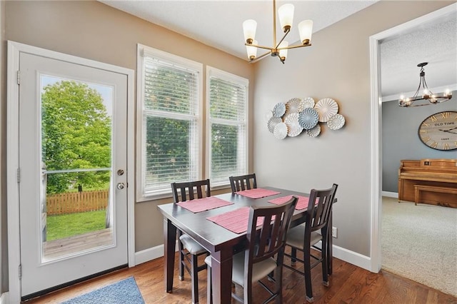 12287 S Mullen Rd, Olathe, KS 66062 - dining area featuring a chandelier, baseboards, and wood finished floors