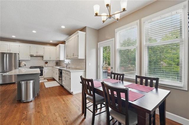 12287 S Mullen Rd, Olathe, KS 66062 - kitchen with stainless steel appliances, a sink, light countertops, backsplash, and white cabinetry
