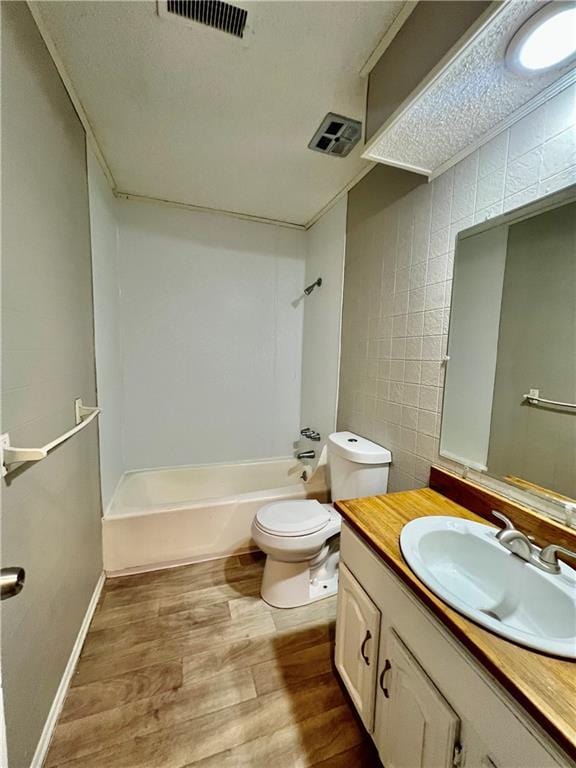 11914 E 59th Ter, Kansas City, MO 64133 - bathroom featuring wood finished floors, bathtub / shower combination, toilet, and vanity