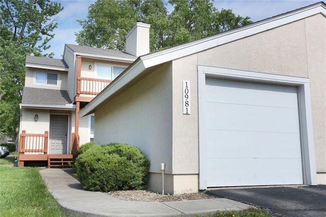 10981 Rosehill Rd, Overland Park, KS 66210 - view of front of home with stucco siding, a chimney, a garage, a balcony, and a shingled roof